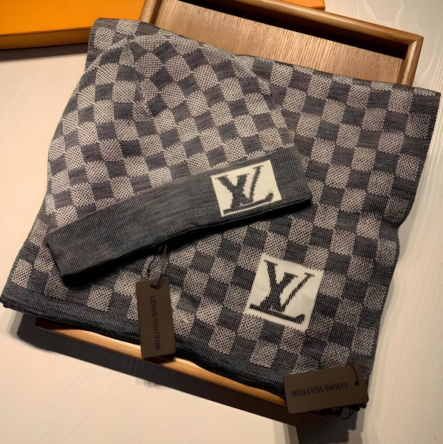 LOUIS VUITTON SCARF AND BEANIE SET IN A GRAY DAMIER PATTERN.